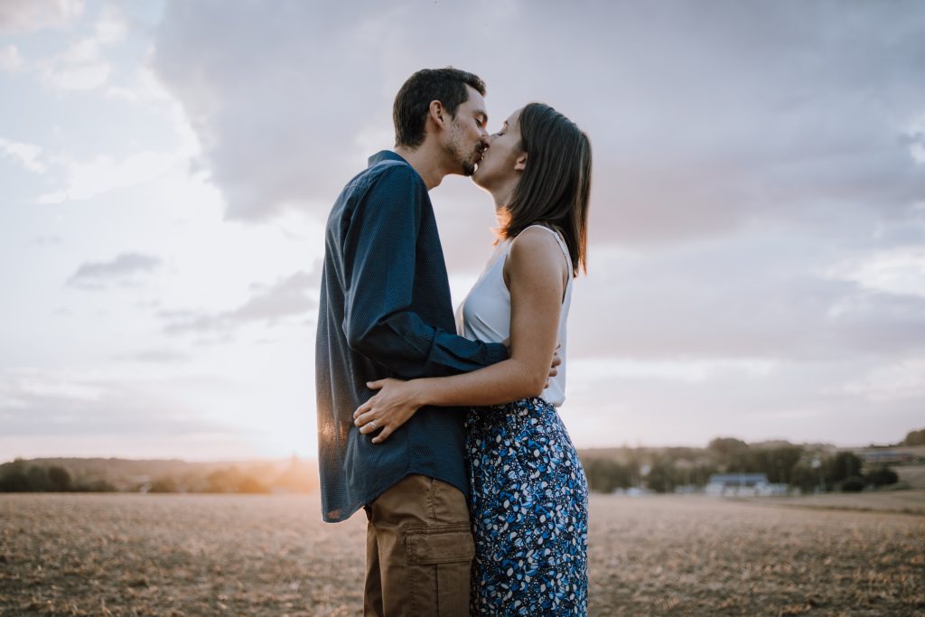 Couple d'amoureux qui s'embrasse au soleil couchant